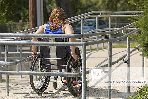 Frau mit einer Rückenmarksverletzung benutzt eine Rollstuhlrampe