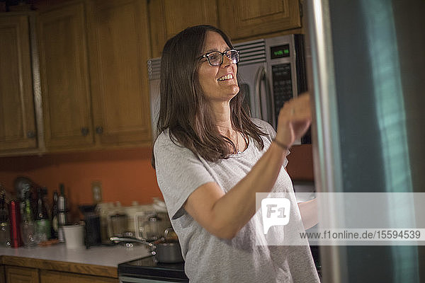 Frau mit Multipler Sklerose schaut in einen Kühlschrank