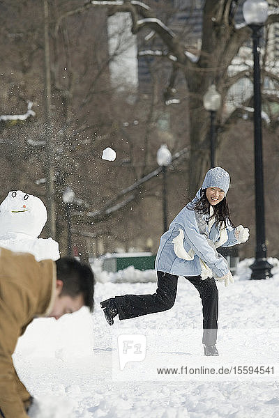 Junges Paar spielt Schneeballschlacht