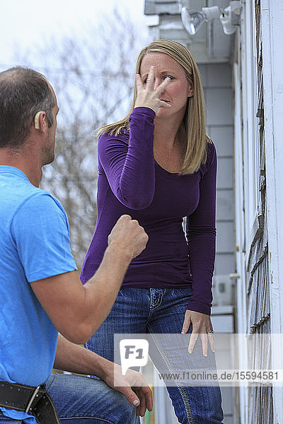 Ein Hausbesitzer kommuniziert mit einem Handwerker in amerikanischer Zeichensprache und sagt Schön und Ja .