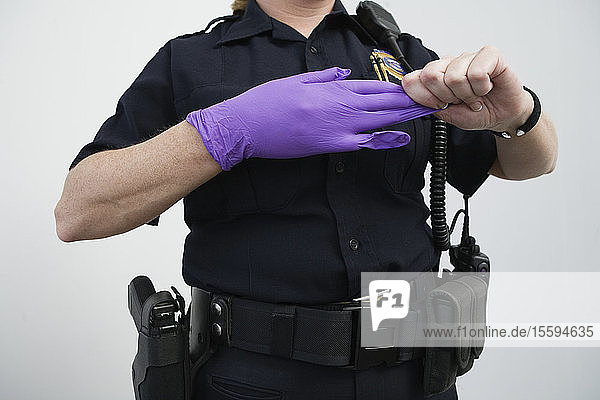 Polizeibeamtin beim Ausziehen eines Handschuhs.