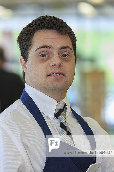 Portrait of a man with Down Syndrome working at a grocery store
