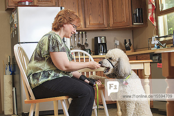 Frau mit RSD füttert ihren Diensthund