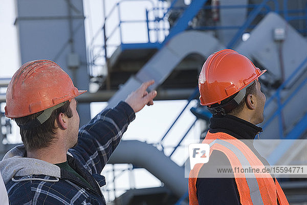 Two engineers discussing at an asphalt plant