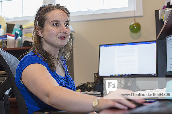 Junge Frau mit zerebraler Lähmung arbeitet am Computer