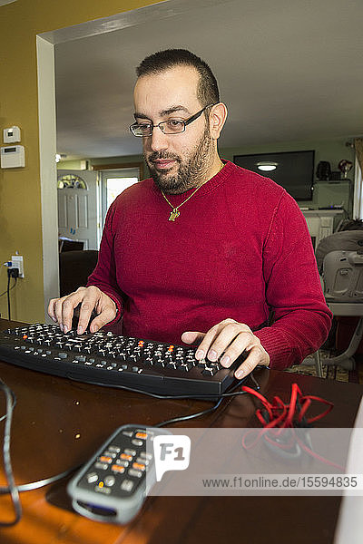Mann mit Sehbehinderung an seiner Tastatur mit einem Bildschirmlesegerät