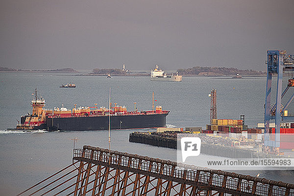 Container ship with cranes at a harbor with Nixes Mate and Boston Lighthouse in the background Boston Harbor Boston Massachusetts USA