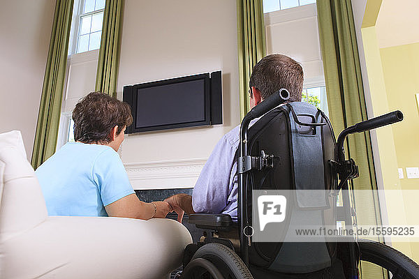 Ehepaar mit zerebraler Lähmung sieht in seinem Haus fern
