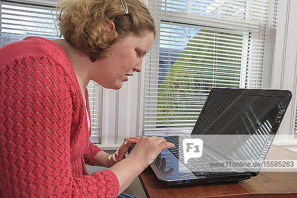 Junge Frau mit Autismus benutzt ihren Laptop
