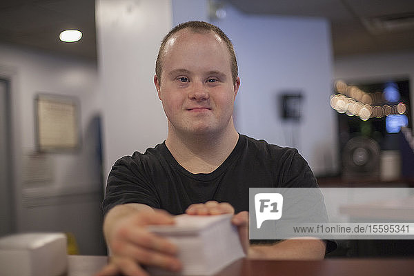 Portrait of waiter with Down Syndrome working in a restaurant