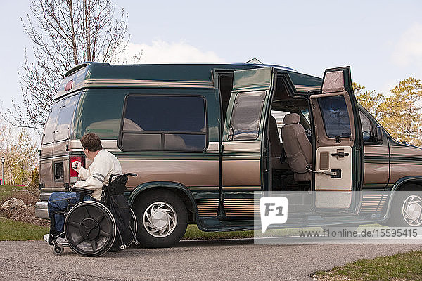 Man with spinal cord injury using magnetized remote to close his accessible vehicle