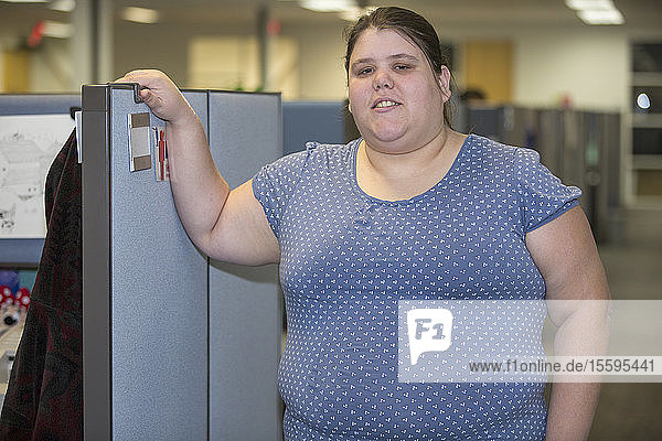 Porträt einer Frau mit einer Lernbehinderung  die in einem Büro arbeitet