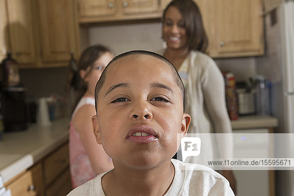 Hispanischer Junge mit Autismus mit seiner Mutter und seiner Schwester in der Küche