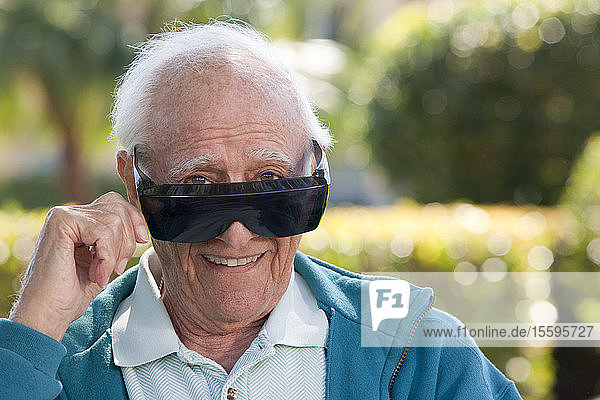 Portrait of a senior man wearing cataract dark glasses