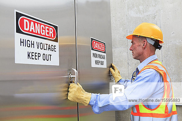 Engineer at electric power plant opening high voltage area doors