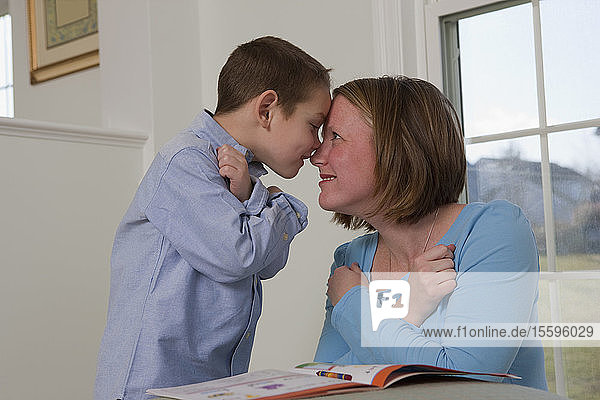 Woman signing the word 'love' in American Sign Language while communicating with her son