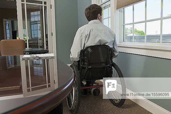 Businessman with spinal cord injury in a wheelchair in an office