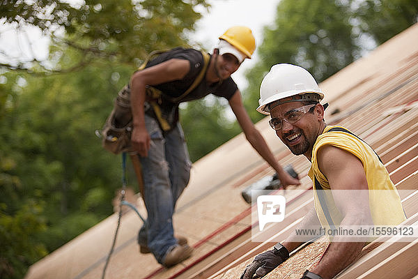 Carpenters working on the roof of a house under construction