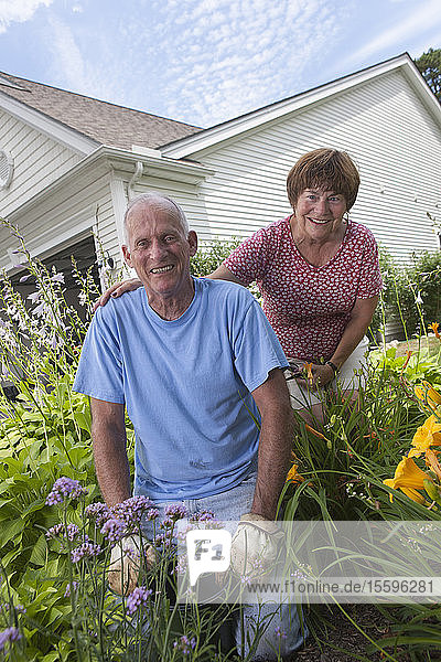 Porträt eines älteren Paares  das sich auf das Pflanzen von Blumen im Garten vorbereitet