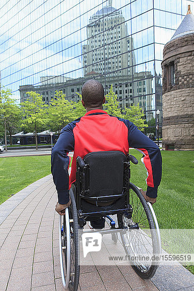 Mann im Rollstuhl  der an Spinaler Meningitis erkrankt war  bewegt sich unabhängig in der Stadt
