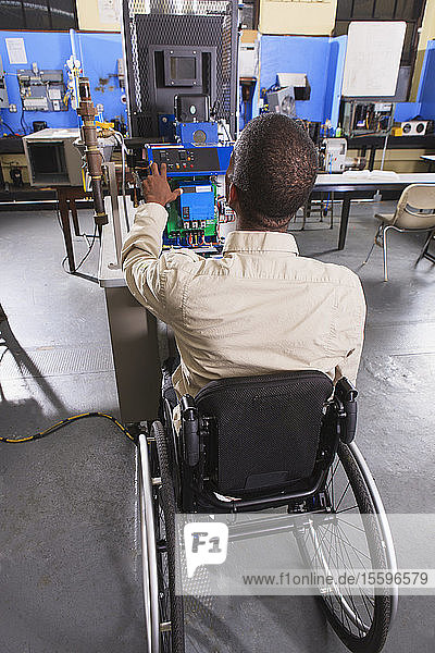 Student im Rollstuhl studiert das elektronische Steuerungssystem eines Ofens im HLK-Klassenzimmer