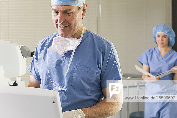 Two surgeons working on a laser machine