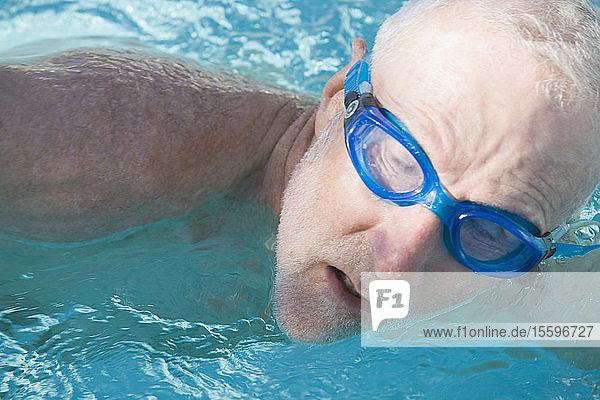 Close-up of a senior man swimming in a swimming pool