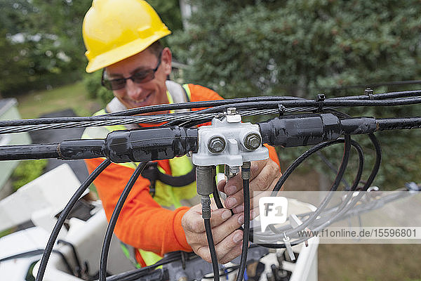 Kabelmonteur beim Anbringen eines Leitungsfilters von einem Kübelwagen aus