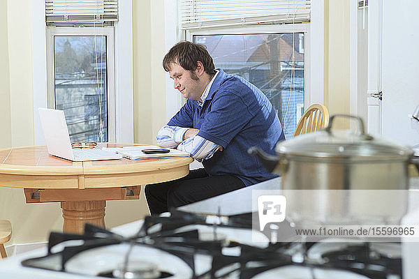 Mann mit Asperger-Syndrom arbeitet beim Kochen in seinem Haus