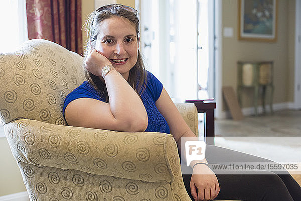 Junge Frau mit zerebraler Kinderlähmung lächelt zu Hause
