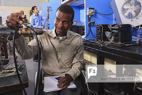 Student im Rollstuhl prüft Brennstoffregelventile am Ofen im HLK-Klassenzimmer