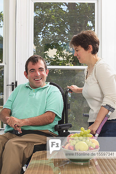 Ehepaar mit zerebraler Lähmung sitzt auf ihrer Terrasse