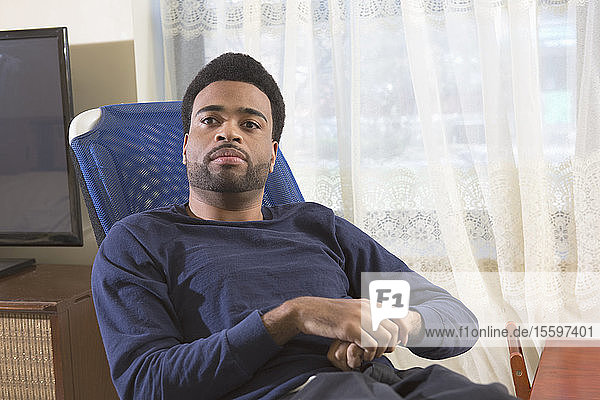Porträt eines afroamerikanischen Mannes mit zerebraler Lähmung zu Hause