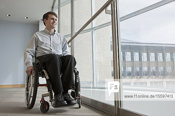 Businessman with spinal cord injury in a wheelchair in an office building