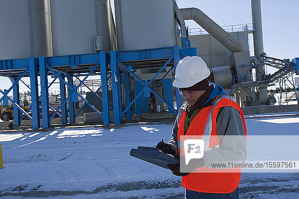 Engineer using an electronic clipboard at a materials plant