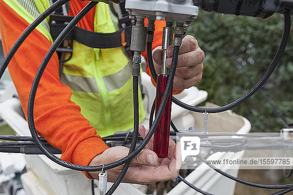 Ein Kabelmonteur benutzt einen Mutternschlüssel  um eine Verbindung von einem Kübelwagen zu lösen