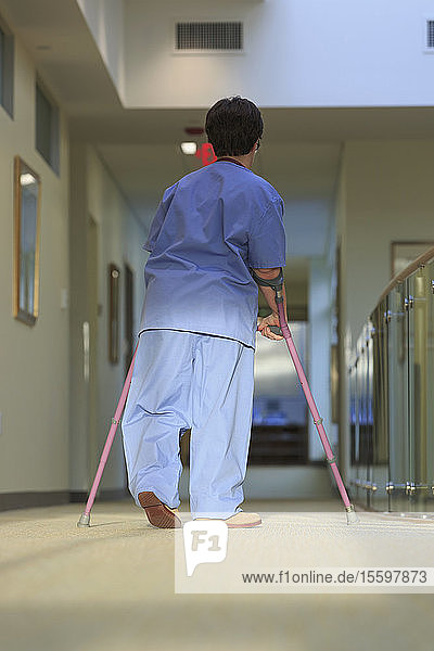 Nurse with Cerebral Palsy walking down the hallway of a clinic with her canes