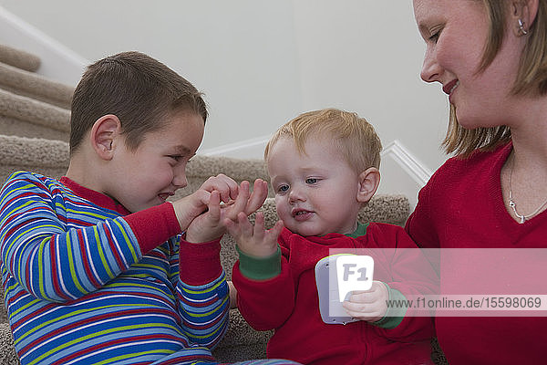 Boy signing the word 'Calculator' in American Sign Language while communicating with his brother