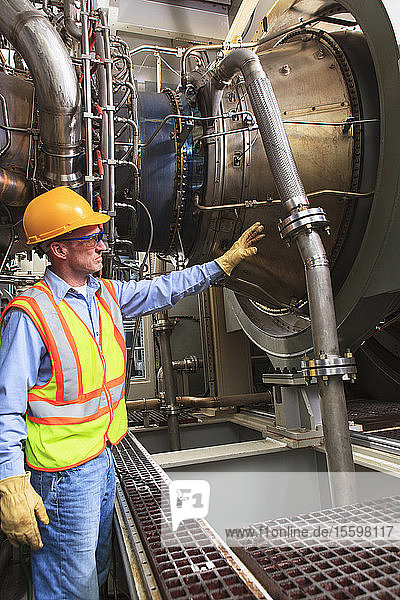 Engineer at fuel ignition stage of gas turbine which drives generators in power plant while turbine is powered down