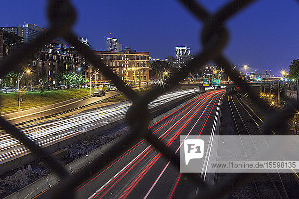 Streifen von Ampeln auf der Straße bei Nacht durch einen Zaun  Mass Avenue  Berkeley Street  Boston  Massachusetts  USA