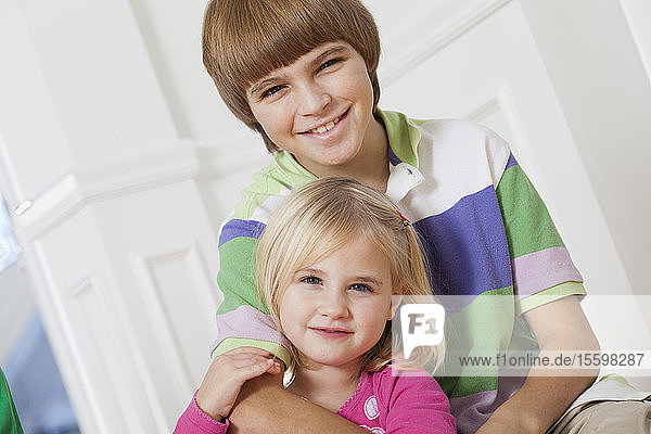 Porträt eines lächelnden Jungen mit seiner Schwester