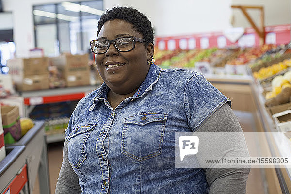 Porträt einer glücklichen Frau mit bipolarer Störung beim Einkaufen im Supermarkt
