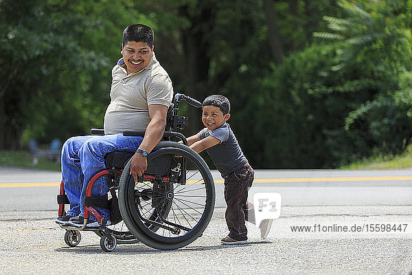 Hispanic man with Spinal Cord Injury in wheelchair with his son