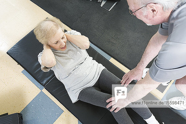 Ein älteres Paar trainiert im Fitnessstudio.