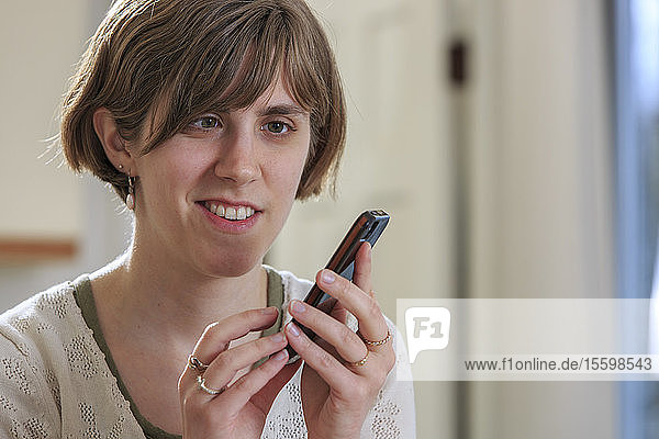 Blinde Frau nutzt Hilfsmittel zum Abhören von Texten auf ihrem Mobiltelefon