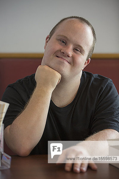 Portrait of happy waiter with Down Syndrome in a restaurant