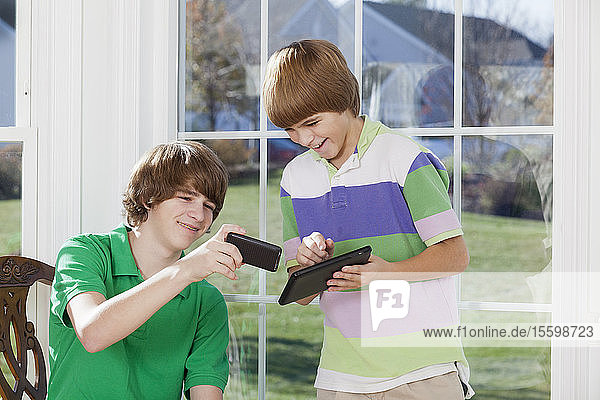 Zwei Jungen benutzen ein digitales Tablet und ein Smartphone