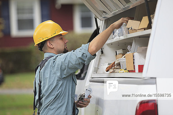 Ein Elektriker holt Material für die Installation aus seinem Lastwagen