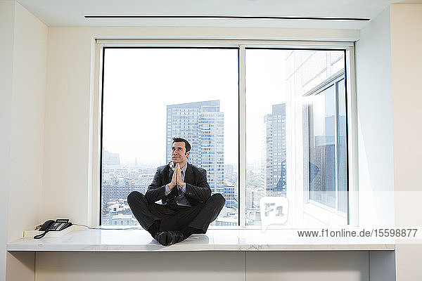 Businessman praying in an office.