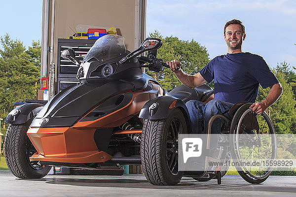 Mann mit Rückenmarksverletzung sitzt im Rollstuhl neben seinem Spezialmotorrad